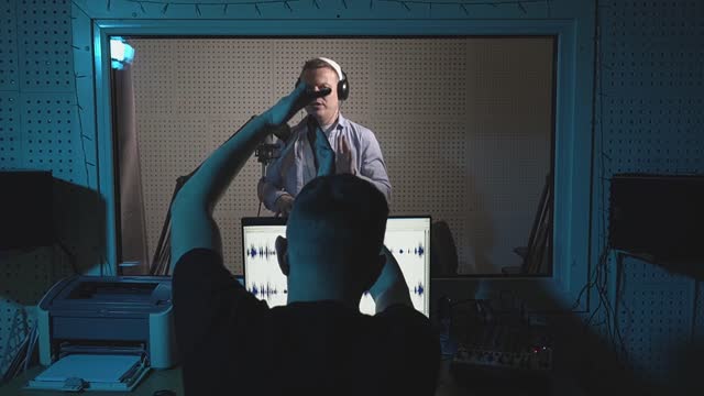 caucasian man speaks into a microphone in a recording studio