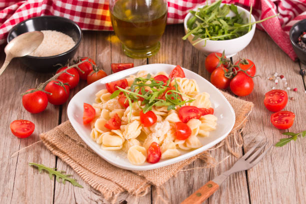 istock Orecchiette pasta with arugula and tomato. 1584733144