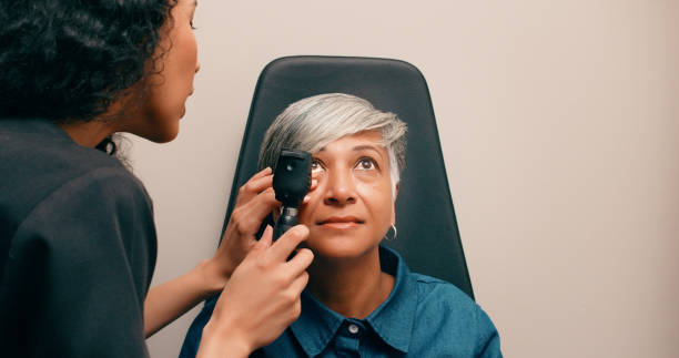 istock Optometry, eye care and senior patient with ophthalmoscope for testing vision, sight and exam. Healthcare, ophthalmology and woman with optometrist with medical machine to scan eyes, pupil and retina 1584740802