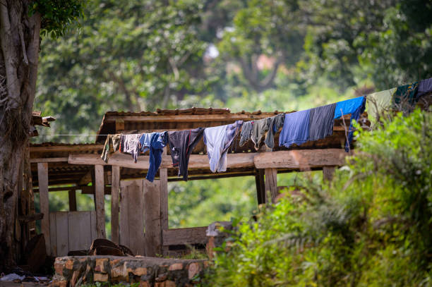 una piccola linea di vestiti davanti a una capanna di legno - clothing east africa color image colors foto e immagini stock