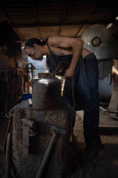 istock Selective focus on an anvil with a blacksmith in the background in a forge shop. 1584747271