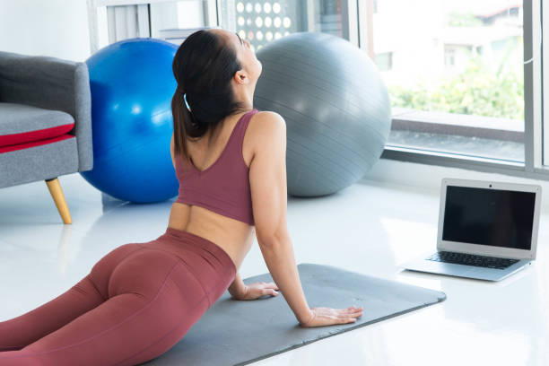 Asiatische junge gesunde Frau trägt Sportware Online-Fitnesstraining mit Laptop zu Hause – Foto