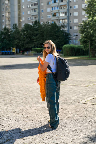 istock Highschool girl with backpack in residential destrict 1584763977