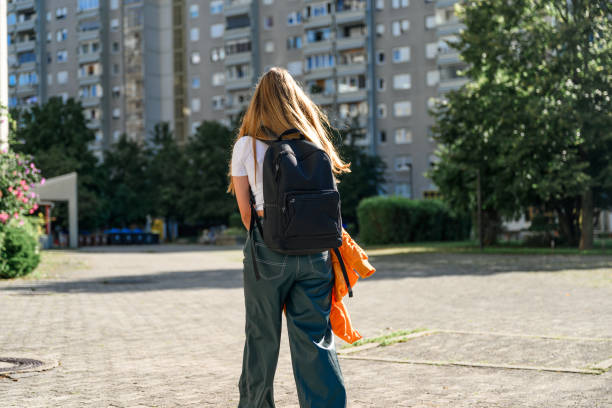 istock Highschool girl with backpack in residential destrict 1584766680