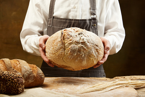 Homemade sourdough bread photography with man's hands. Recipe idea.Concept of food, health, traditions, bakery and cooking. Ad