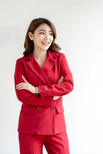Caucasian successful confident young businesswoman in red suit standing with arms crossed  isolated in white background