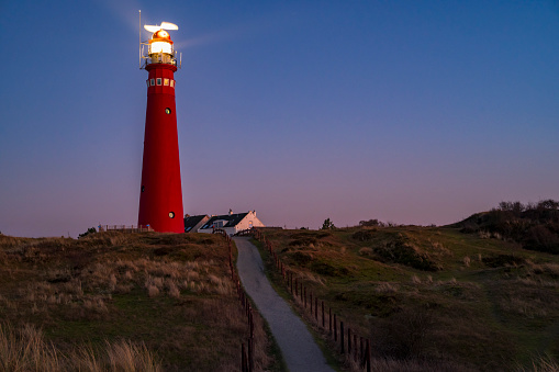 Schiermonnikoog panoramic view in the dunes with the lighthouse during sunset at the wadden island during a beautiful winter day. Schiermonnikoog is part of the Frisian Wadden Islands and is known for its beautiful natural scenery, including sandy beaches, rolling dunes, and lush wetlands.