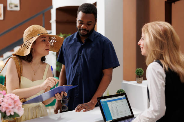 istock Travelers signing hotel reservation form 1584780362