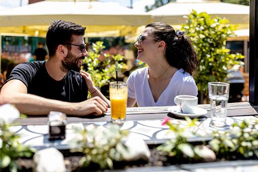 Cherishing the beauty of togetherness, the couple embraces quality time in the enchanting cafe garden, relishing in shared moments filled with laughter, affection, and connection