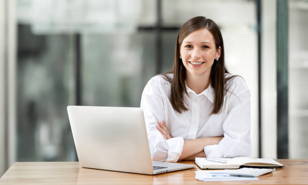 istock Young female entrepreneur working on a laptop in a modern workspace. 1584809307