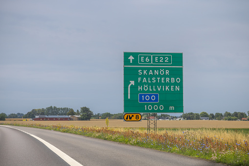 Skane, Sweden - July 29th 2023: Road sign showing directions in rural surroundings just before harvest time in the southern part of Sweden