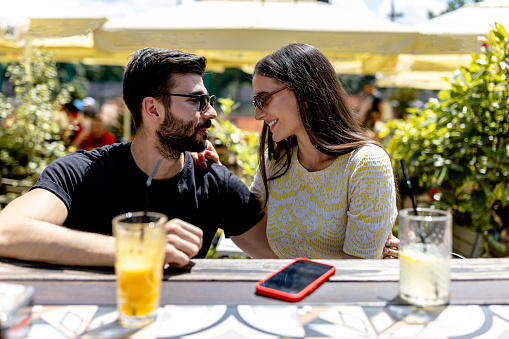 A romantic rendezvous unfolds as the couple enjoys a delightful al fresco dining experience in the intimate ambiance of the cafe garden, relishing in the magical atmosphere and each other's company