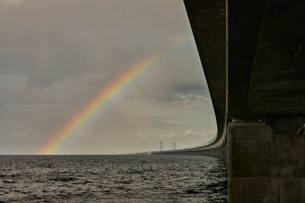 Great Belt with dramatic sky Great Belt Bridge view East from Funen. Weather changing and rainbow shows up storm cloud sky dramatic sky cloud stock pictures, royalty-free photos & images