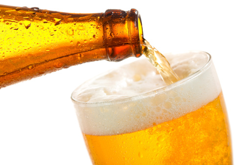 Beer pouring into glass on a white background