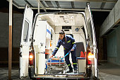 Young female paramedic organizing ambulance interior