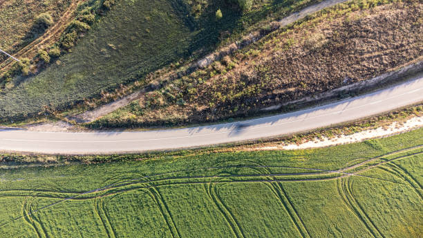 istock Overhead view of a secondary road surrounded by cultivated areas. 1584890541
