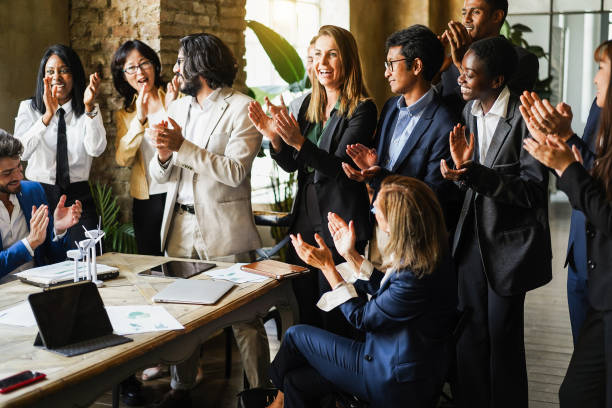 Multigenerational colleagues clapping hands for a succesful green energy project inside business modern office - Teamwork greeting each others for environmental deal - Main focus on asian man face colegas multigeneracionales aplaudiendo para un exitoso proyecto de energía verde dentro de la oficina moderna del negocio - trabajo en equipo saludándose unos a otros para el acuerdo ambiental - enfoque principal en la cara del hombre asiático