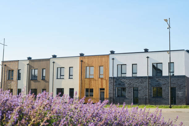 istock Long row of small houses of neutral colors with rectangular windows 1584948431