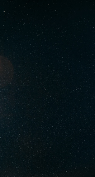 Natural Night Starry Sky. Glowing Stars And Meteoric Track Trail In Dark Night Starry Sky Background. Glowing Stars And Meteorite Trail.