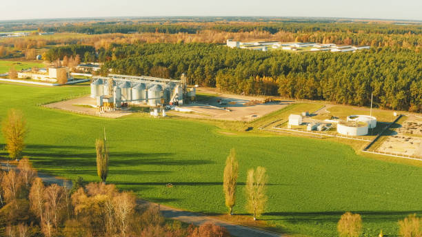 istock Aerial View Modern Granary, Grain-drying Complex, Commercial Grain Or Seed Silos In Rural Landscape. Corn Dryer, Inland Grain Terminal, Grain Elevators In Field 4K. Biogas Plant Or Bioreactor For Fermentation Of Chicken Manure 1584963375