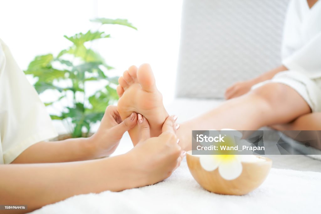 Close up foots spa.  Spa body treatment for beauty and aroma therapy product for female feet and hand spa relax and healthy care,  Masseur doing massage with treatment sugar scrub Close up foots spa.  Spa body treatment for beauty and aroma therapy product for female feet and hand spa relax and healthy care,  Masseur doing massage with treatment sugar scrub.  Thailand. Healthy and Relax Concept Adult Stock Photo