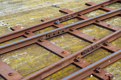 Railway carriage is waiting for loading on the rails, the details of the carriage wheels are covered.