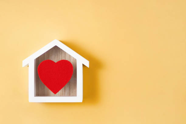 Home with Heart Empty heart shaped felt ornament with wooden house on yellow background felt heart shape small red stock pictures, royalty-free photos & images