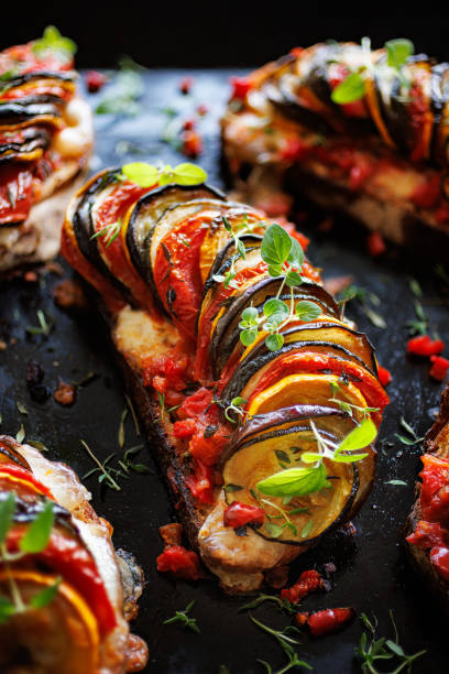 istock Grilled sourdough bread open faced sandwich with sliced vegetables on a black background, close up 1584992631