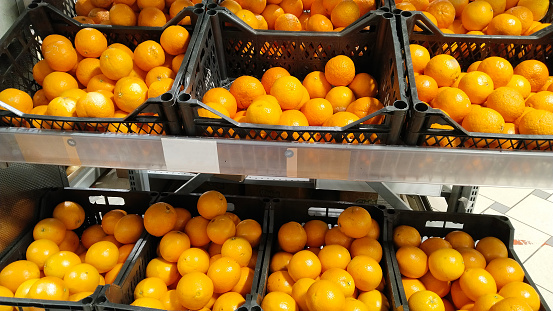 Oranges in boxes on supermarket shelves. Food products. Retail industry. Grocery shopping. Greengrocers. Mart. Inflation concept. Local farmers market. Fruit suppliers. Discount Store. Vitamin C.