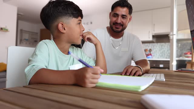 Hispanic father with son doing homework