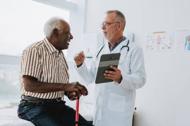 istock Doctor attending senior male patient using digital tablet 1585065571