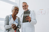Doctor attending senior patient using digital tablet
