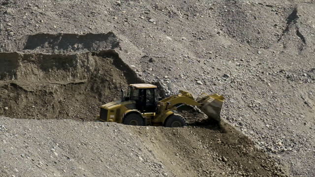 Yellow scraper excavator in a stone quarry for sand mining
