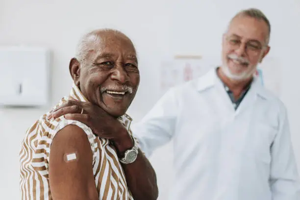 Photo of Senior man bandaging vaccine on arm