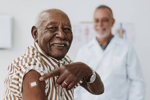 Senior man bandaging vaccine on arm