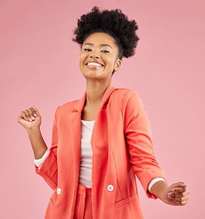 Smile, dancing and portrait of a woman in a studio with music, playlist or album for celebration. Happiness, excited and young African female model moving to a song isolated by a pink background.