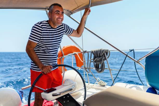 istock Man is driving a sailboat and enjoying it. 1585117160