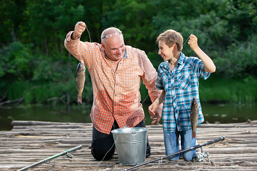 Grandfather and grandson fishing with fishing rods and fish.Summer fishing in the village.