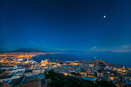 Naples, Italy. Top View Skyline Cityscape In Evening Lighting. Tyrrhenian Sea And Landscape With Volcano Mount Vesuvius. City In Night Illuminations