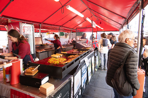 People wandering around Bergens world famous outdoor food market showing off its natural produce from land and sea