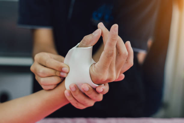 istock Hand occupational therapist making assistive device for immobilize patient hand. Splint service for hand injury rehabilitation of occupational therapy clinic. 1585144787