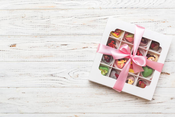 istock Box with sweet chocolate candies on color background, Various candy sweets. Valentines day gift box. Top view flat lay with copy space 1585148228