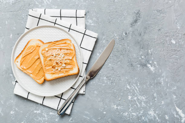 Peanut butter sandwiches or toasts on light table background.Breakfast. Vegetarian food. American cuisine top view vith copy space