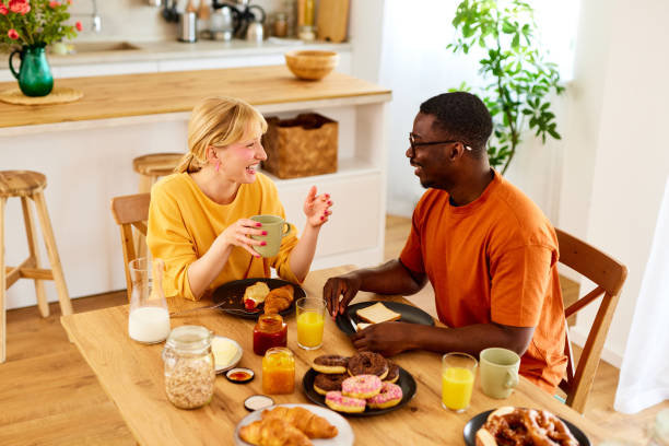 istock Multiracial couple enjoying breakfast together at home 1585159168