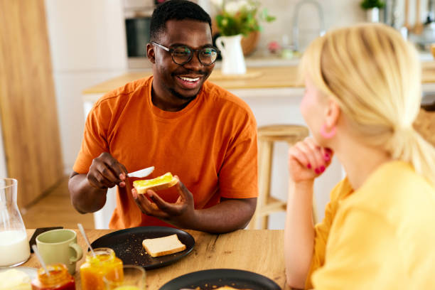 istock Multiracial couple enjoying breakfast together at home 1585159726