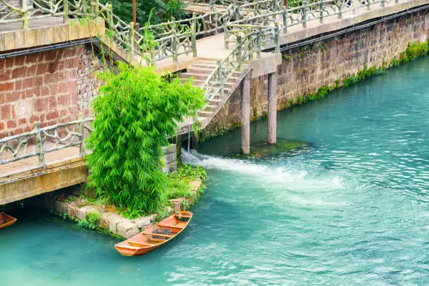 Wooden boat on the Tuojiang River (Tuo Jiang River) with azure water in Phoenix Ancient Town (Fenghuang County), China. Fenghuang is a popular tourist destination of Asia.