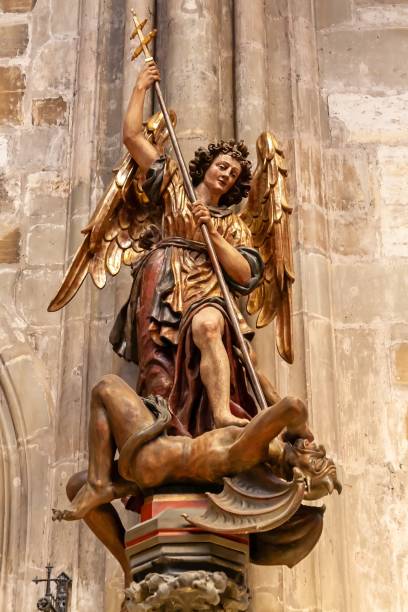 Archangel Saint Michael (St Michel in french) statue close-up, on the roofs of Basilica Notre Dame de Fourviere built between 1872 and 1884, in a dominant position overlooking the city of Lyon, and dedicated to the Virgin Mary. This image was taken during a sunny summer day in famous Lyon city in Rhone department, Auvergne-Rhone-Alpes region in France (Europe), outside Basilica Notre Dame de Fourviere, on Fourviere hill.