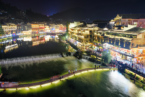 Fenghuang, China - September 23, 2017: Fabulous aerial night view of Phoenix Ancient Town and the Tuojiang River (Tuo Jiang River). Fenghuang is a popular tourist destination of Asia.
