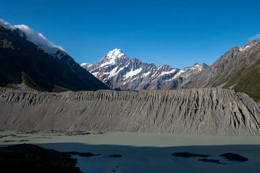 The dirt slope and water surface at the foot of Mount Cook, South Island, New Zealand.