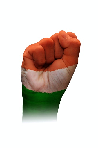 A horizontal cutout of a fist of hand painted in three vibrant colored bands in orange, white and green. . The image denotes confidence, strength and determination.There is no text and Copy space for text. These colors are in the flag of India, Niger and also of Ireland and Côte d'Ivoire (Ivory Coast) country. Can be used for national festivals, events, national teams related backdrops of these countries like Republic Day, Independence Day celebrations.